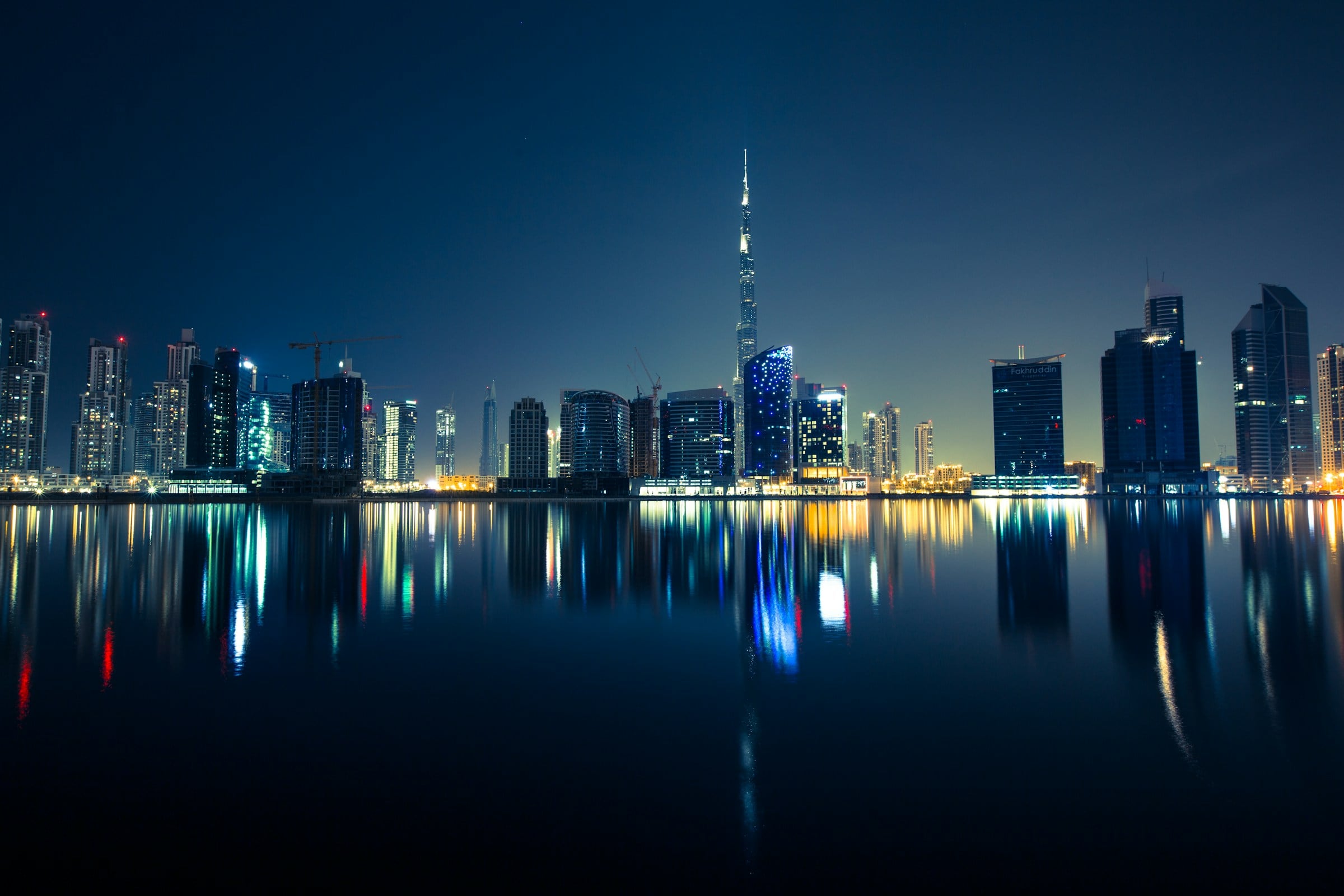 Downtown Dubai at night, reflected in still water