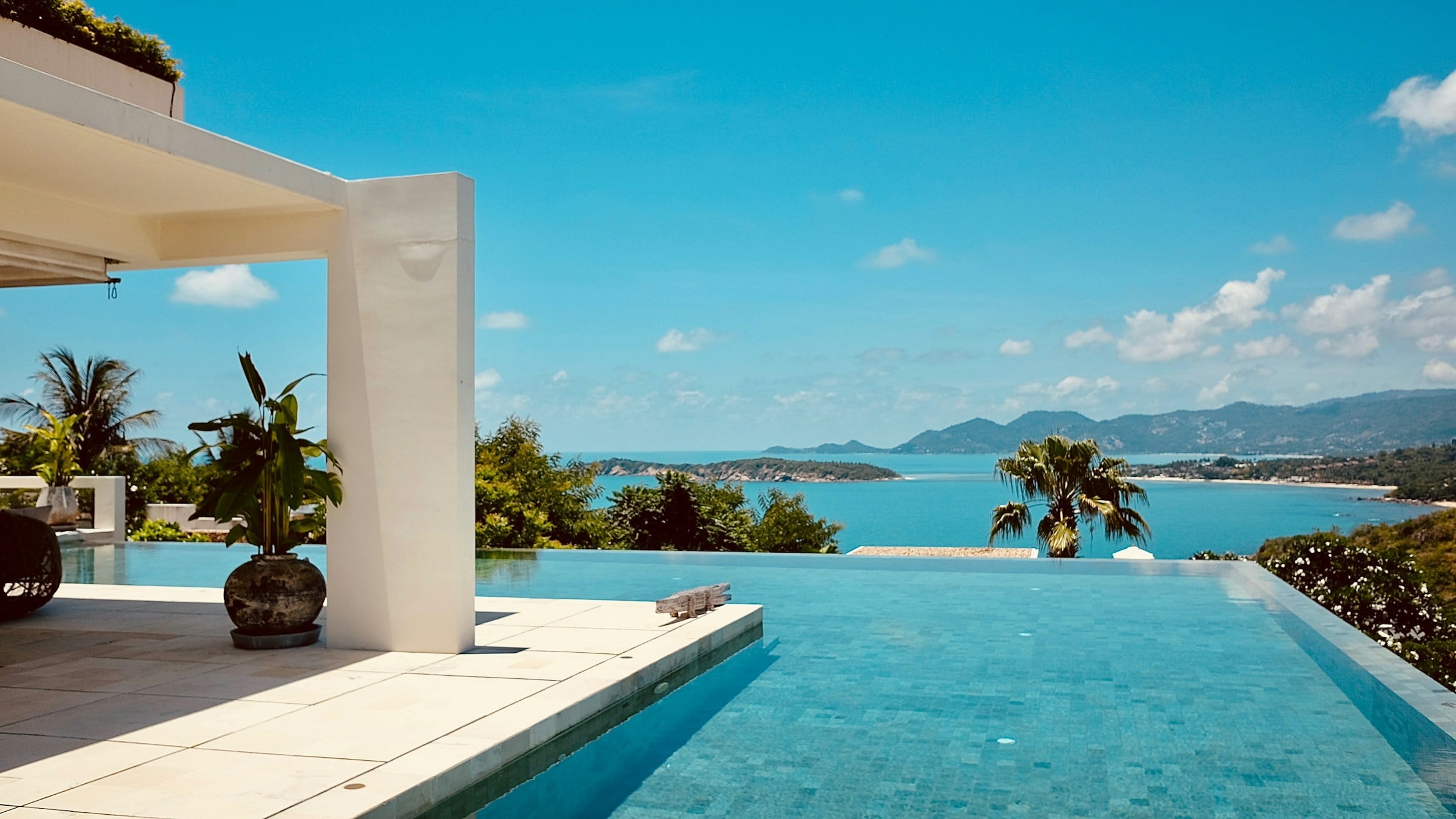 An infinity pool above a blue bay